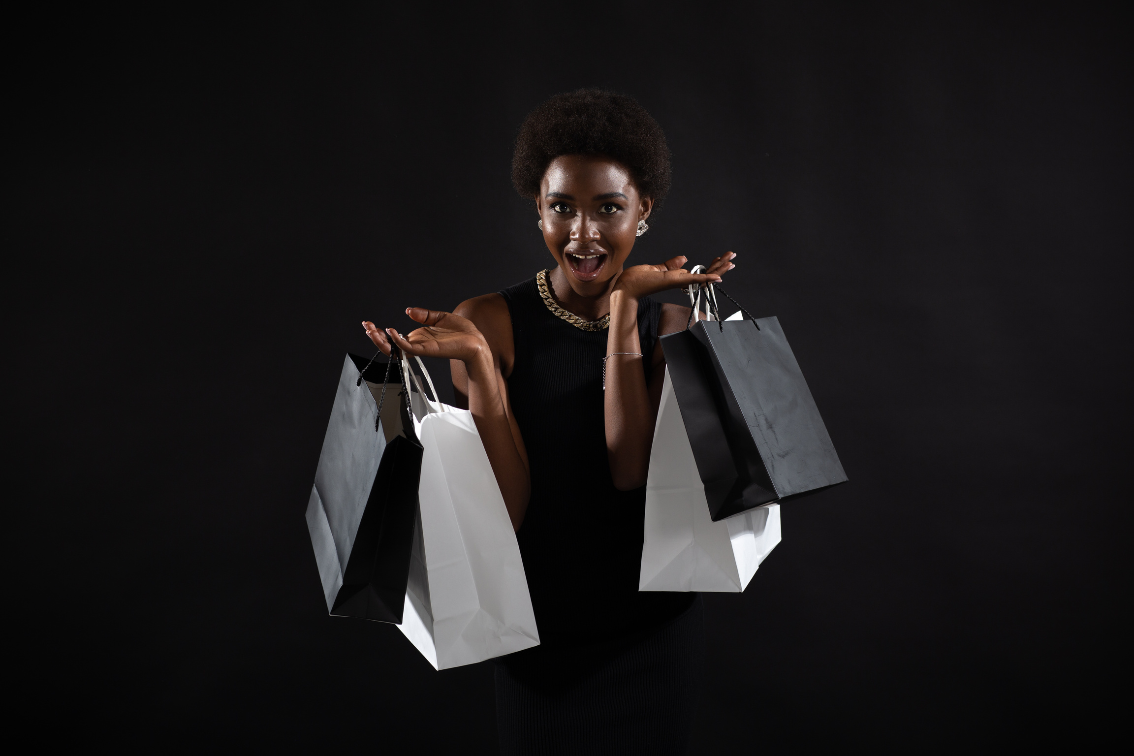 African American Woman Holds Black Shopping Bags. Sale and Discounts on Market and Black Friday Concept.