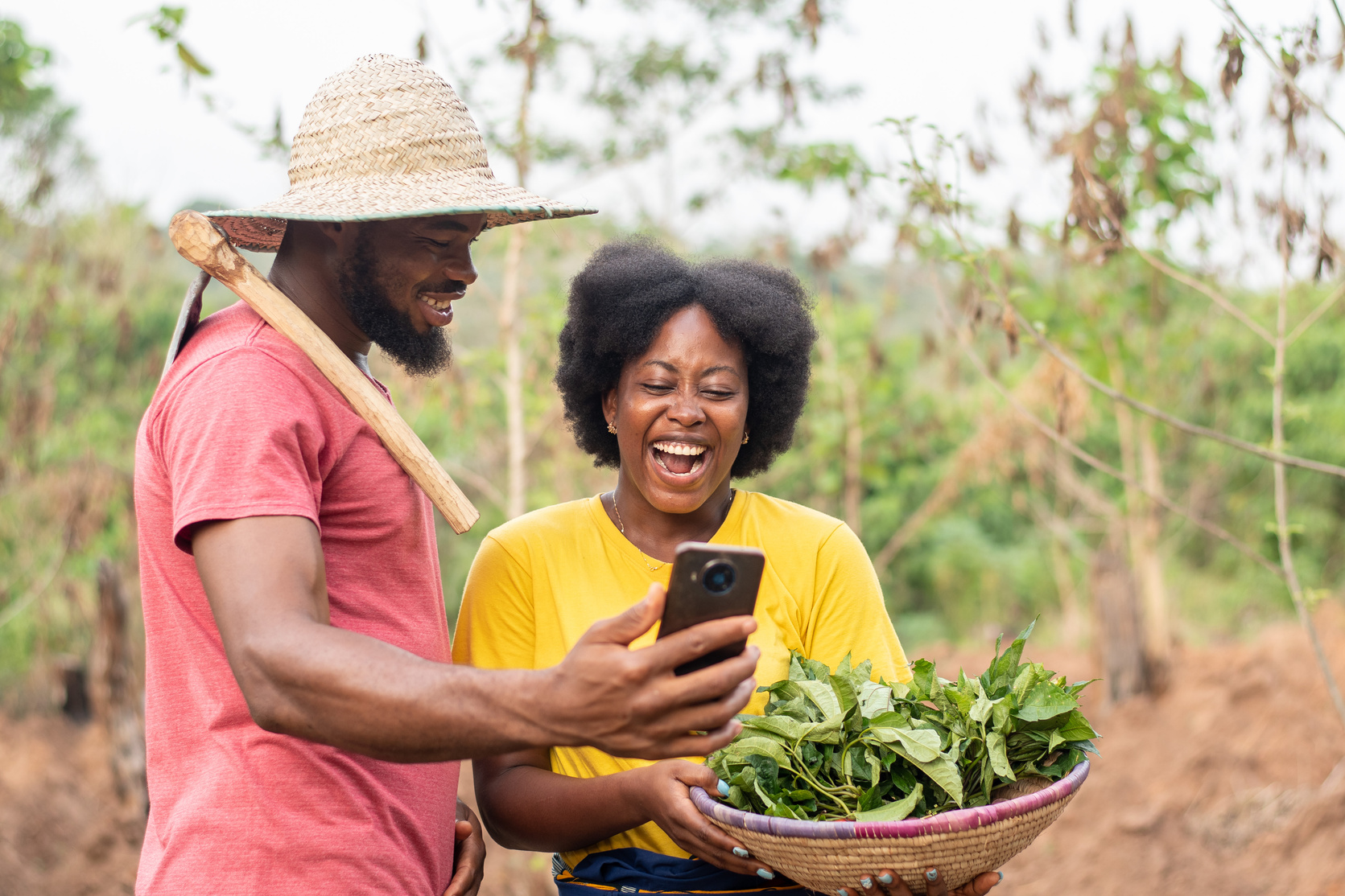 excited african farmers checking a phone together